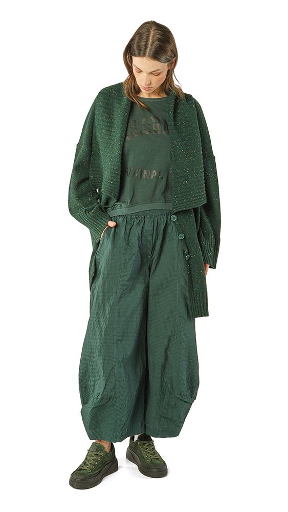 Frau trägt oversized grünen Pullover mit weitem Rock und robusten Schuhen, lässiger Look.