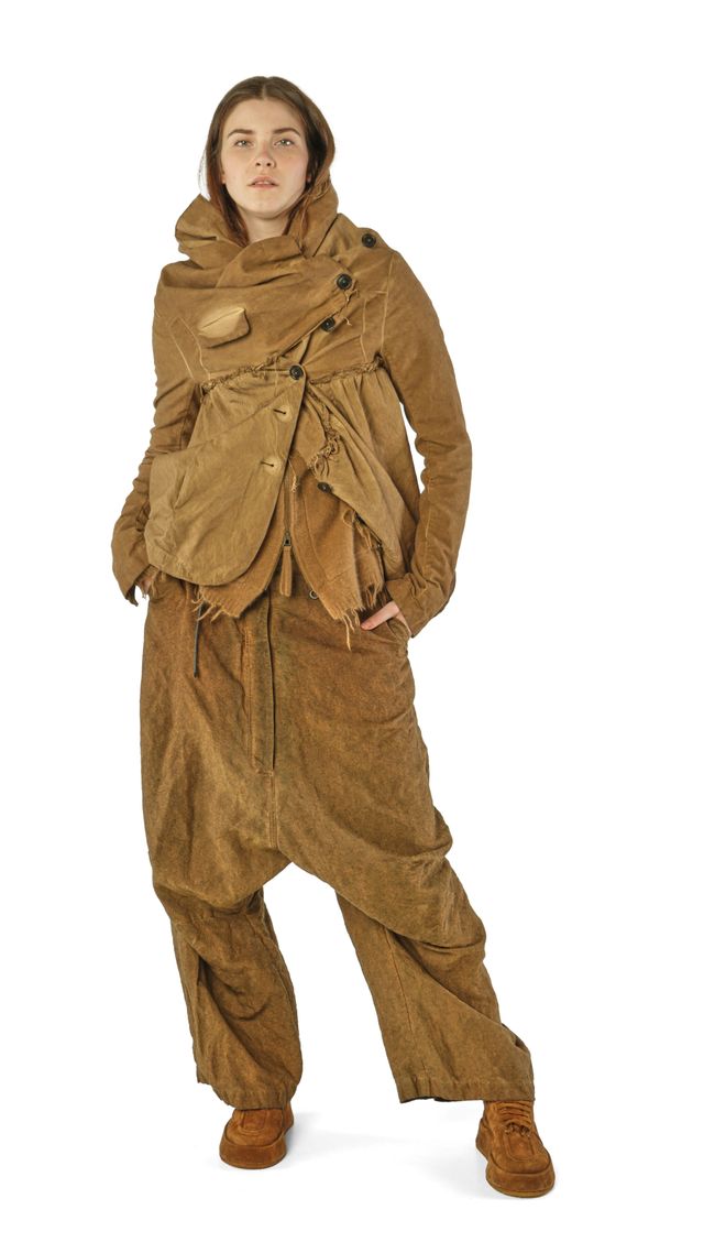 Person trägt rustikale, braune Overall-Kombi mit weitem Schnitt und Accessoires, stilvoll und lässig.