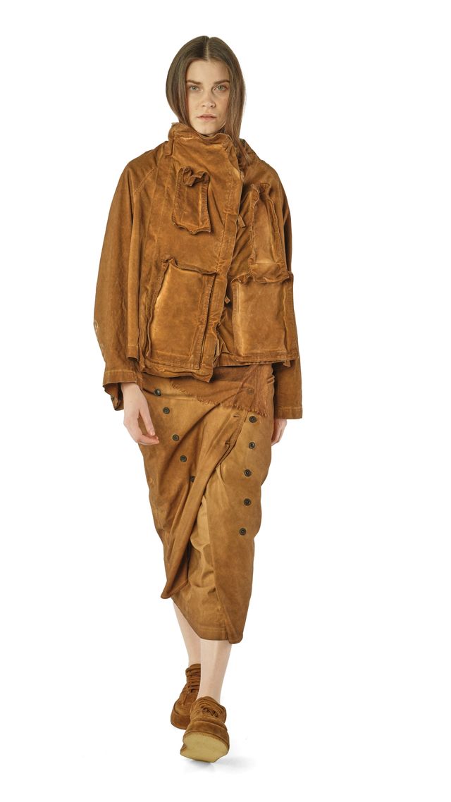 Frau trägt oversized braune Lederjacke mit weitem Hosenrock und Stiefeln, lässiger Stil.