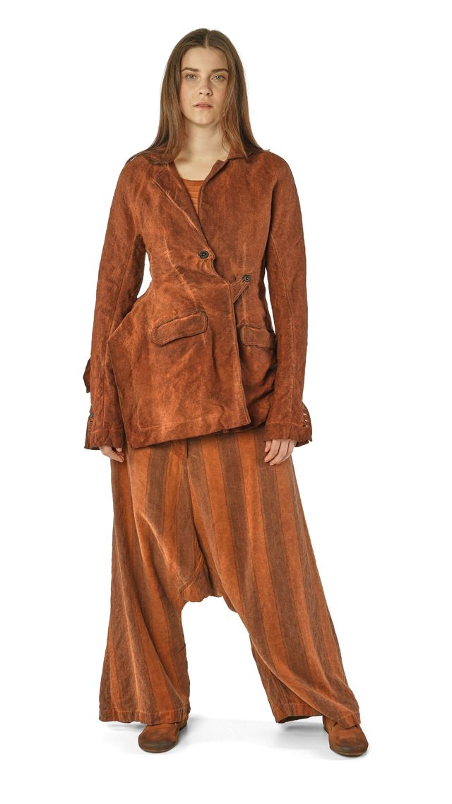 Frau trägt rustikalen, braunen oversized Mantel mit weitem Haremhosen-Set, natürlicher Look.
