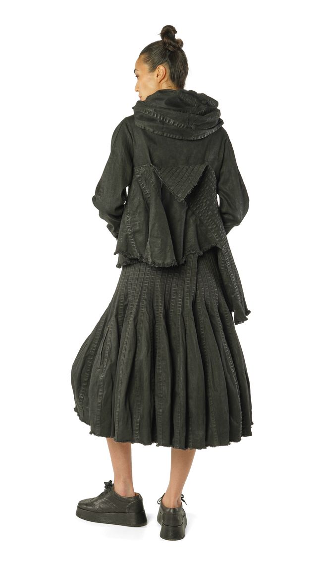 Frau trägt oversized schwarzen Wollmantel mit weitem Rock und Stulpenhandschuhen, von hinten fotografiert.