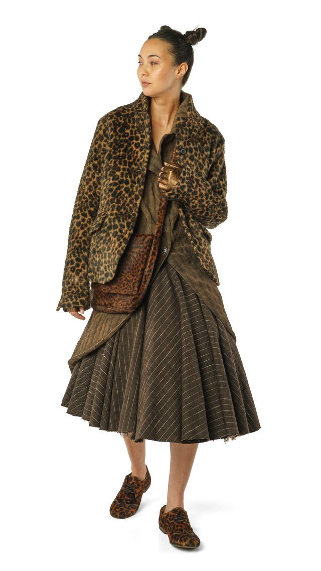 Frau in eleganter Leoparden-Jacke und glitzerndem Rock mit Accessoires, stilvoll gekleidet.