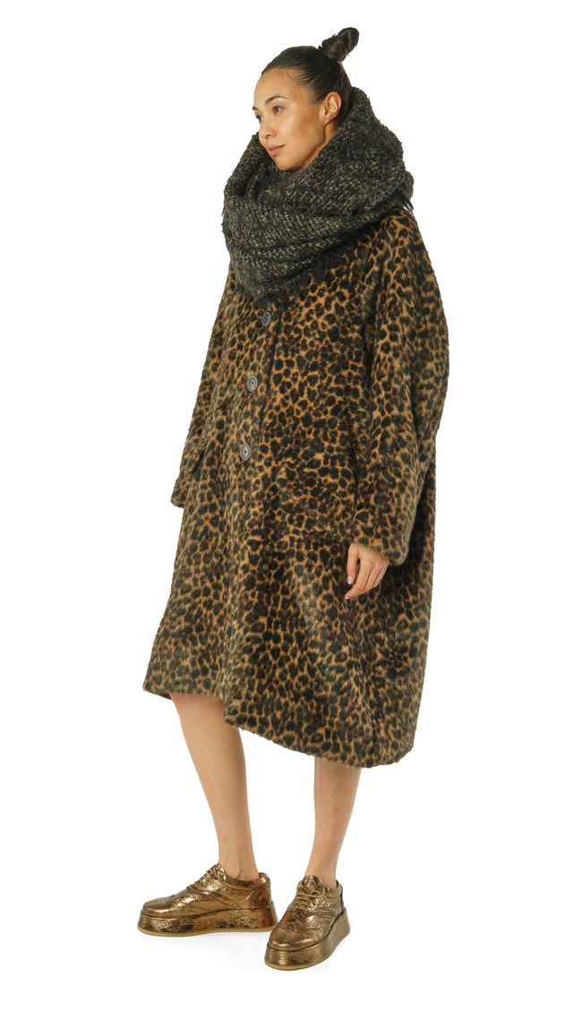 Person trägt langen Leopardenmantel mit Schal und robusten Schuhen.